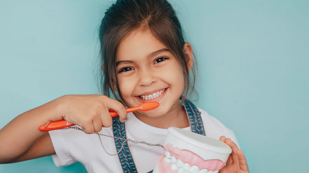 child brushing her teeth